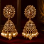 Gold-toned jhumka earrings with intricate stonework and pearl drops – GlowingFusions artificial jewelry